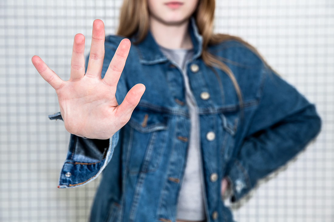 Bild einer Frau, die Handfläche ausstreckt um "Halt" zu symbolisieren